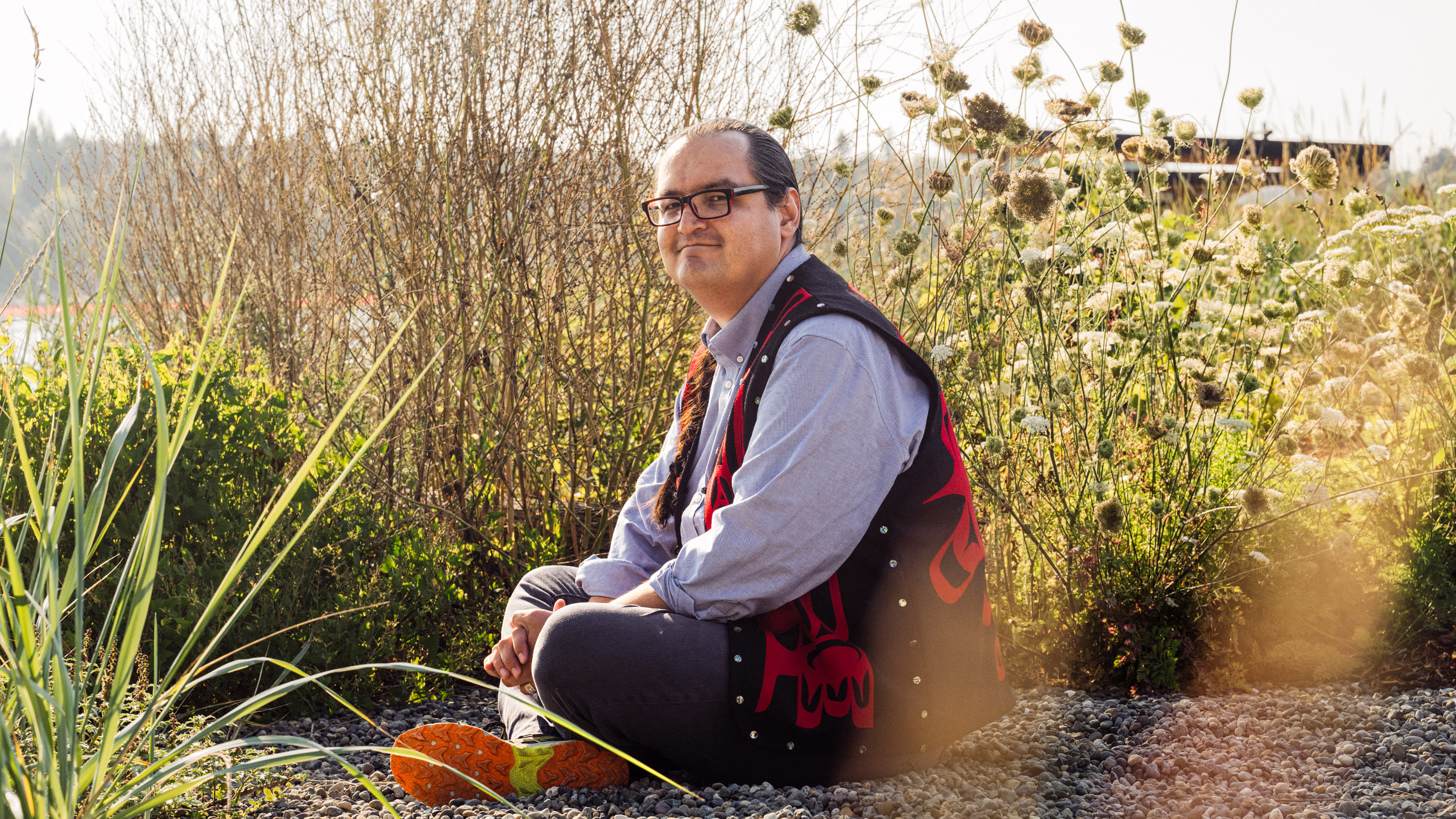 Anthony Jones sitting on the ground in tall grass